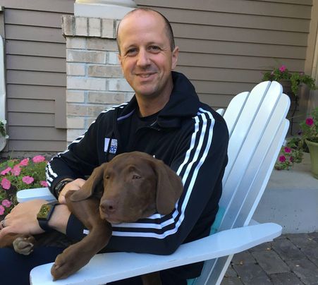 Owner with a chocolate Lab puppy